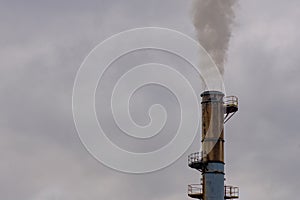 Industrial smokestack billowing greenhouse gasses
