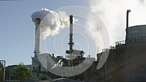 Industrial smokestack with smoke on blue sky background