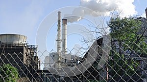 Industrial smokestack with smoke on blue sky background