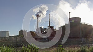 Industrial smokestack with smoke on blue sky background