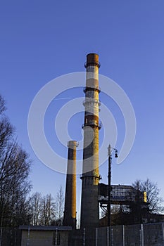 Industrial smokestack on sunny day with blue sky and copy space.