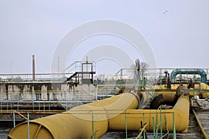 Industrial space with lots of pipes and communications on a background of blue sky. old water treatment plant on the city`s water