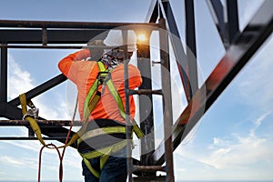 Industrial steel roof truss welders wear safety clothing on the construction site. Fall arrestor device for worker with hooks for