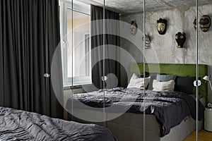 Industrial style bedroom with mirrored wardrobe
