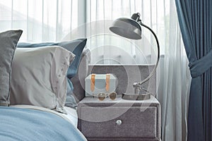 Industrial style reading lamp next to blue color scheme bedding