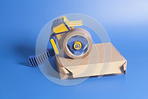 Industrial tape dispenser on a cardboard box