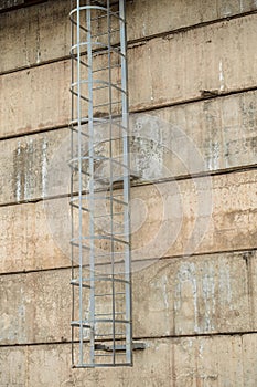 Industrial technical steel safety staircase on a panel wall photo