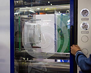 Industrial technician operate injection molding press machine