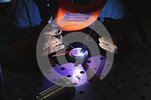An industrial tig welder works in a workshop