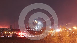 Industrial timelapse of Mariupol steel plant operations at night, glowing furnaces, smokestack emissions envelope sky