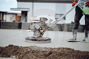 Industrial tools - helicopter concrete floor, screed  finishing. Construction worker finishing concrete screed with power trowel