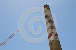 Industrial tower and crane against blue sky photo