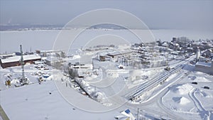 Industrial town on river bank in winter. Clip. Top view of town with marine industry near river bank. Marine industrial