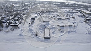 Industrial town on river bank in winter. Clip. Top view of town with marine industry near river bank. Marine industrial