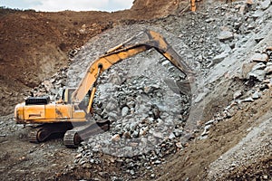 Industrial track type excavator digging at a quarry or a construction site