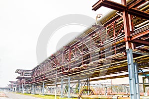 Industrial trestle for pipes. Iron pipes in the oil refinery, petrochemical plant