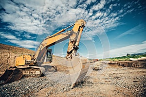 Truck loader, excavator with heavy duty scoop moving earth and loading dumper trucks during roadworks at highway photo