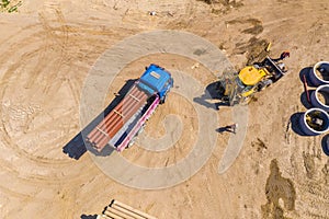 Industrial truck loader excavator moving earth and unloading. Aerial view