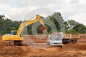 Industrial truck loader excavator moving earth and unloading int