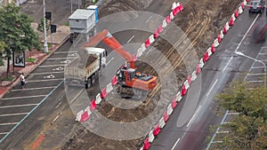 Industrial truck loader excavator moving soil and unloading into a dumper truck timelapse