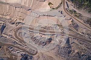 Industrial trucks moves along the road in the sand quarry