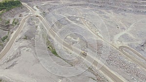 Industrial trucks moves along the road in the sand quarry