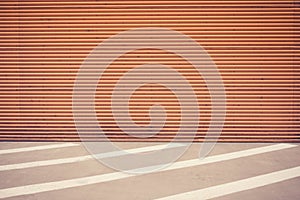 Industrial, urban background. Orange metal wall and empty parking lot