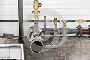 Industrial valve on a gas or heating pipe. Installation of a heating unit in a production room. Metal pipes for heating