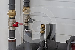 Industrial valve on a gas or heating pipe. Installation of a heating unit in a production room. Metal pipes for heating