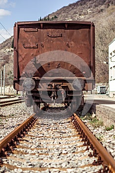 Industrial view of the back of a brown vagon covered with rust.