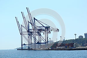 Industrial view of sea port warehouse, container spreaders and gantry cranes. Import export, global logistics
