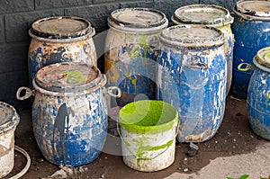 Industrial Waste, Plastic barrels of paint. High Angle View Of Liquids In Containers Against Wall.