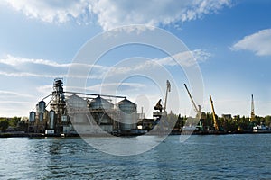 Industrial waterfront with grain elevator and cranes. Infrastructure for logistics, ship loading. Harbor dock panorama