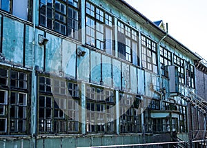 Industrial weathered urban building with rusting window grill and discoloured painted wall surface