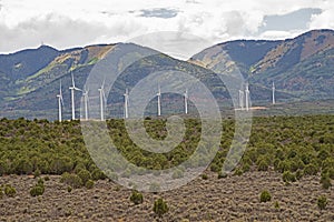 Industrial windmills create a wind farm in the landscape.