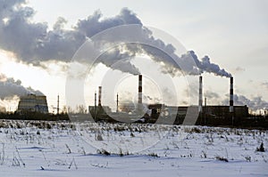 industrial winter scenery: smoke and steam from oil refinery, steel mill, and power plant on a clear sunny day. Emissions smog