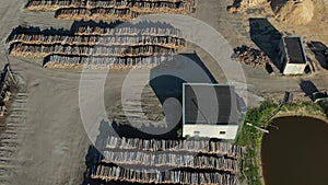 Industrial wood log stacks in sawmill lumberyard aerial