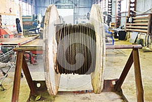 Industrial wooden reel with steel rope in workshop