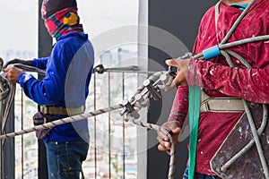 Industrial worker adjusting climbing gear preparing safety rope.