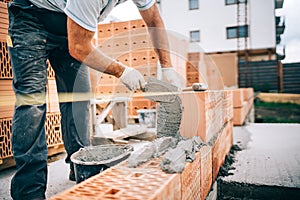 industrial worker, bricklayer installing bricks on construction site