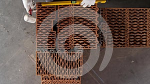 Industrial worker building exterior walls, using hammer and level for laying bricks in cement. Stock footage. Detail of