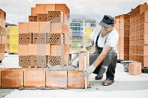 Construction worker building walls and working with bricks on construction site