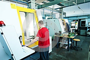 Industrial worker at cnc milling machine cente