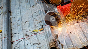 Industrial worker cutting aluzinc metal sheet