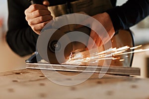 Industrial worker cutting metal with many sharp sparks. Selection focus to cutting machine. Copyspace