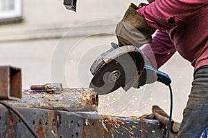 Industrial worker cutting and welding metal with many sharp sparks. Worker cutting metal with grinder.