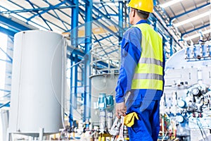 Industrial worker in factory with tools