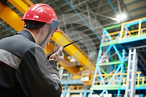 Industrial worker on factory with walkie talkie transmitter