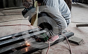 Industrial Worker at the factory welding closeup. Electric wheel grinding on steel structure in factory.