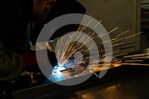 Industrial worker at the factory welding steel construction. Welder